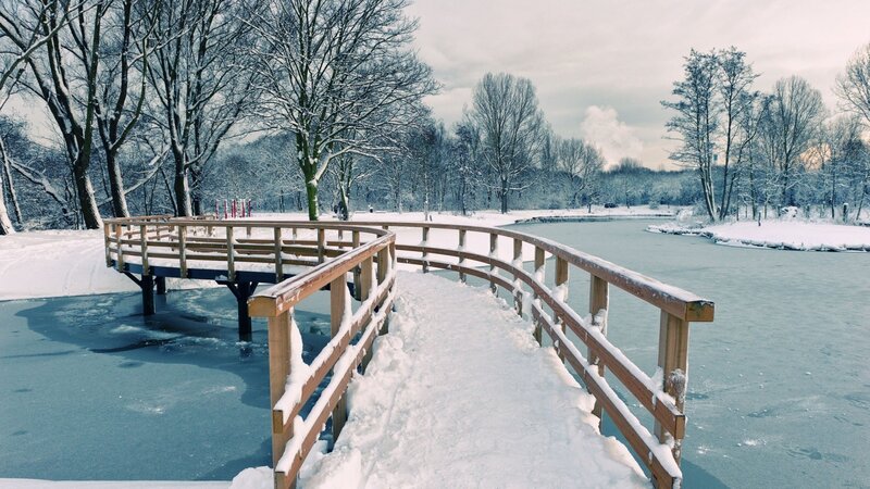 Snowy bridge over frozen lake