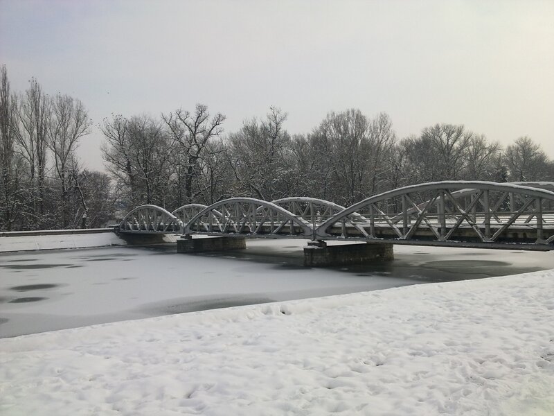 Snowy bridge over frozen river