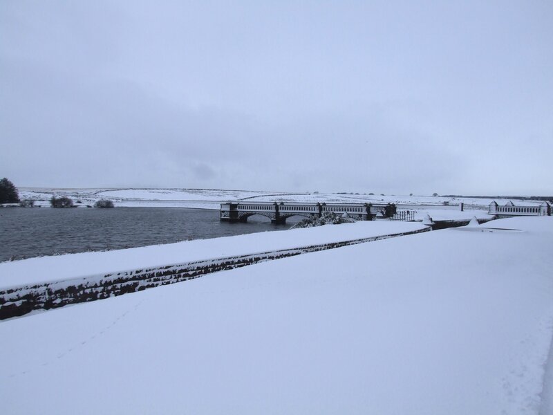 Snowy bridge over reservoir