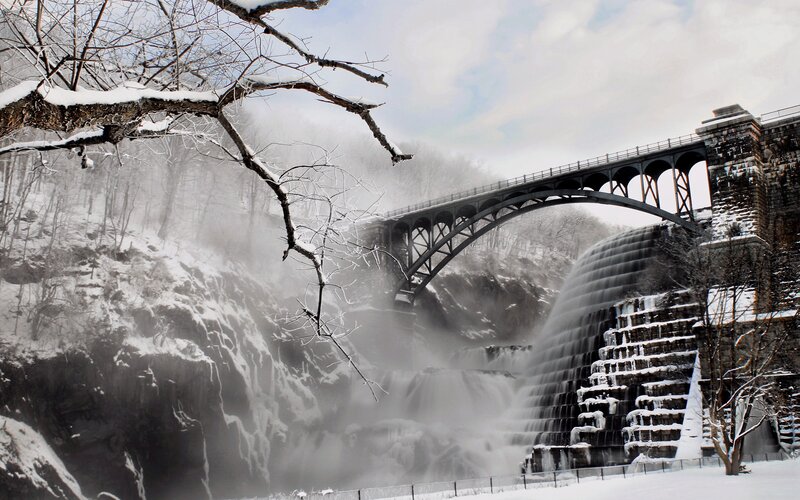 Snowy bridge over waterfall