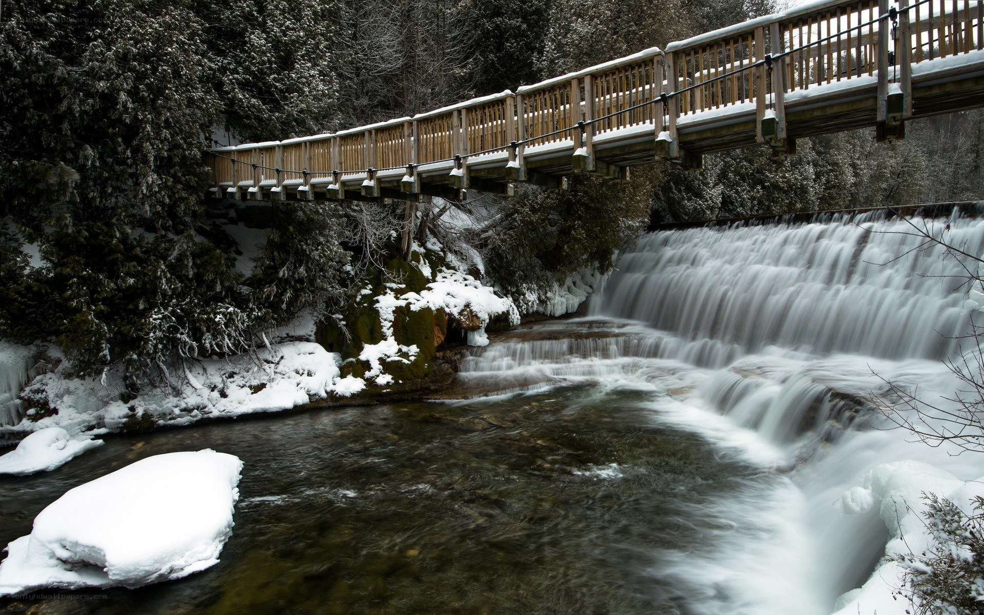 Snowy bridge over waterfall