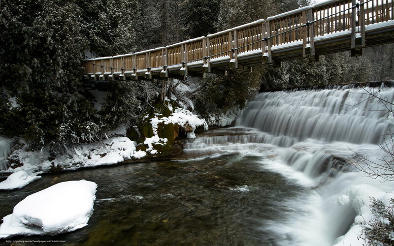 Snowy bridge over waterfall
