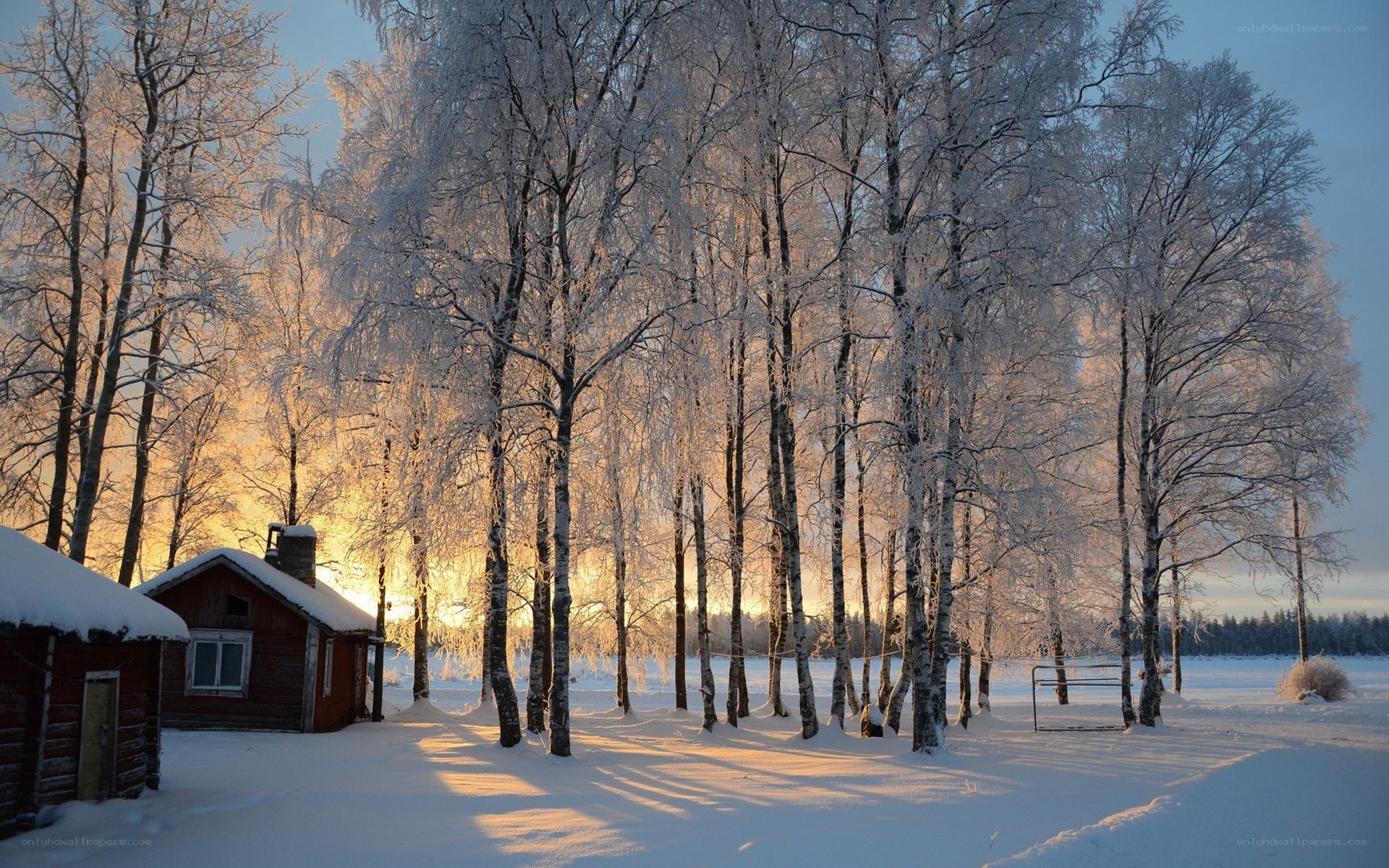 Snowy cabin at sunset