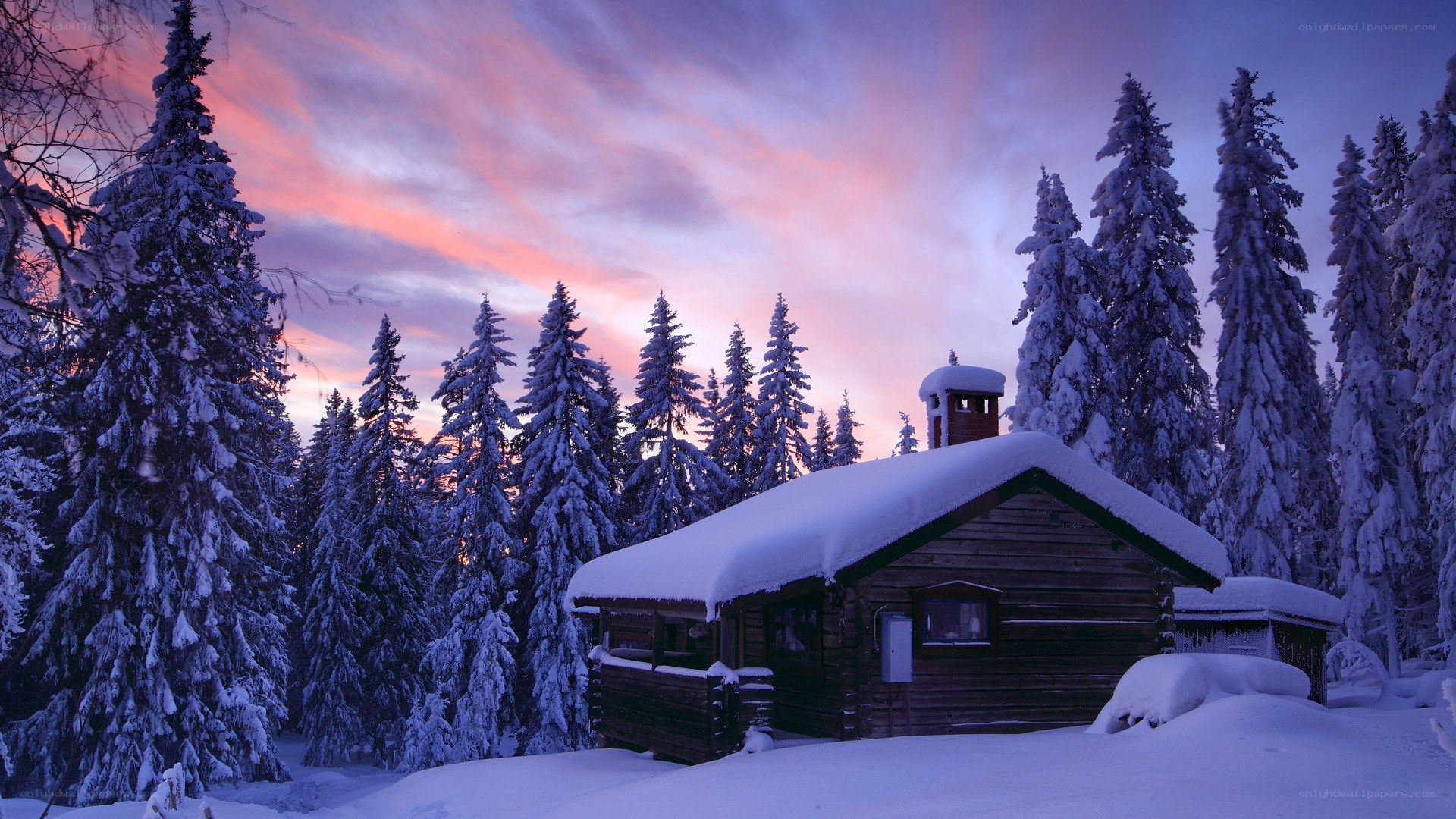 Snowy cabin at sunset