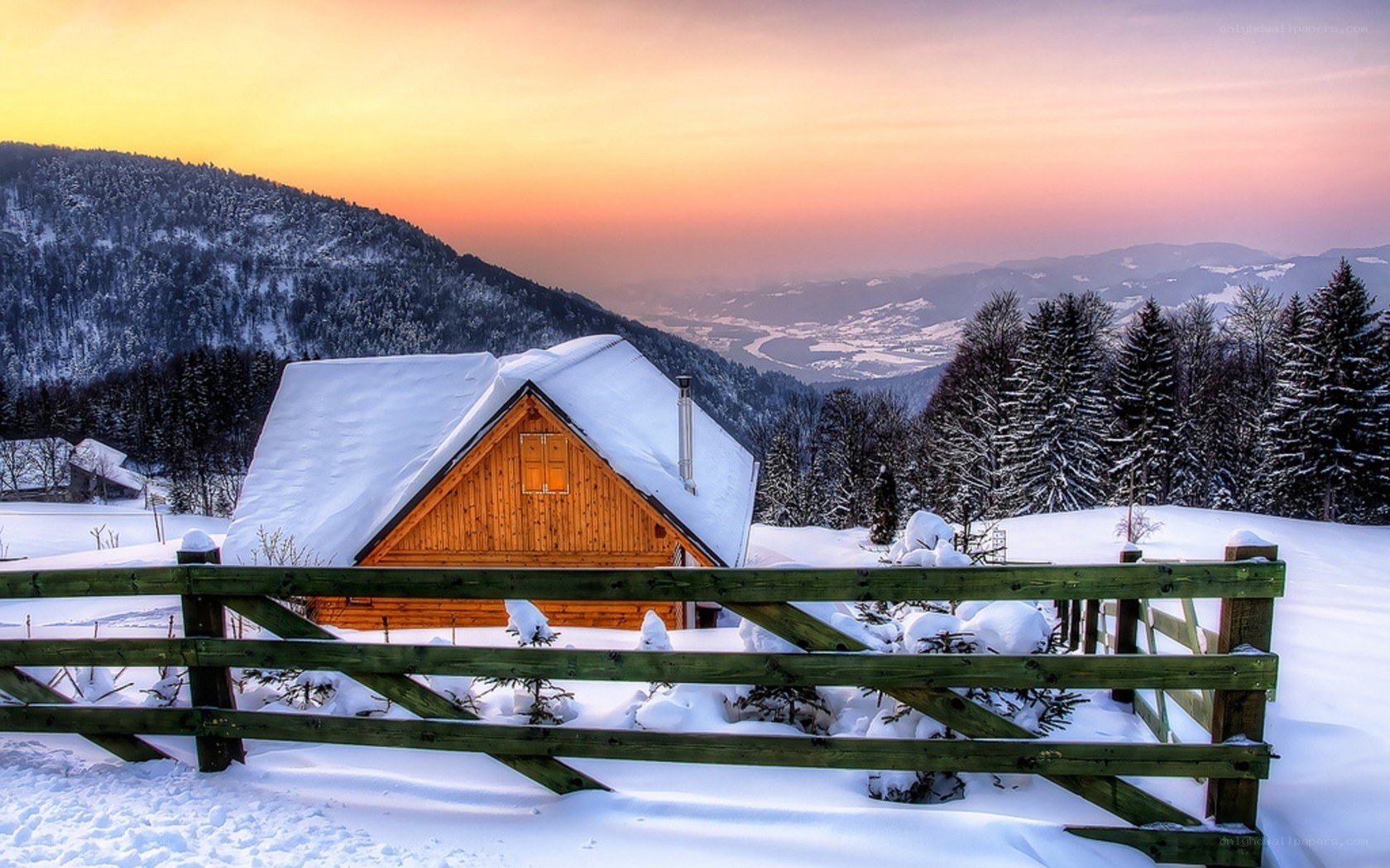 Snowy cabin at sunset