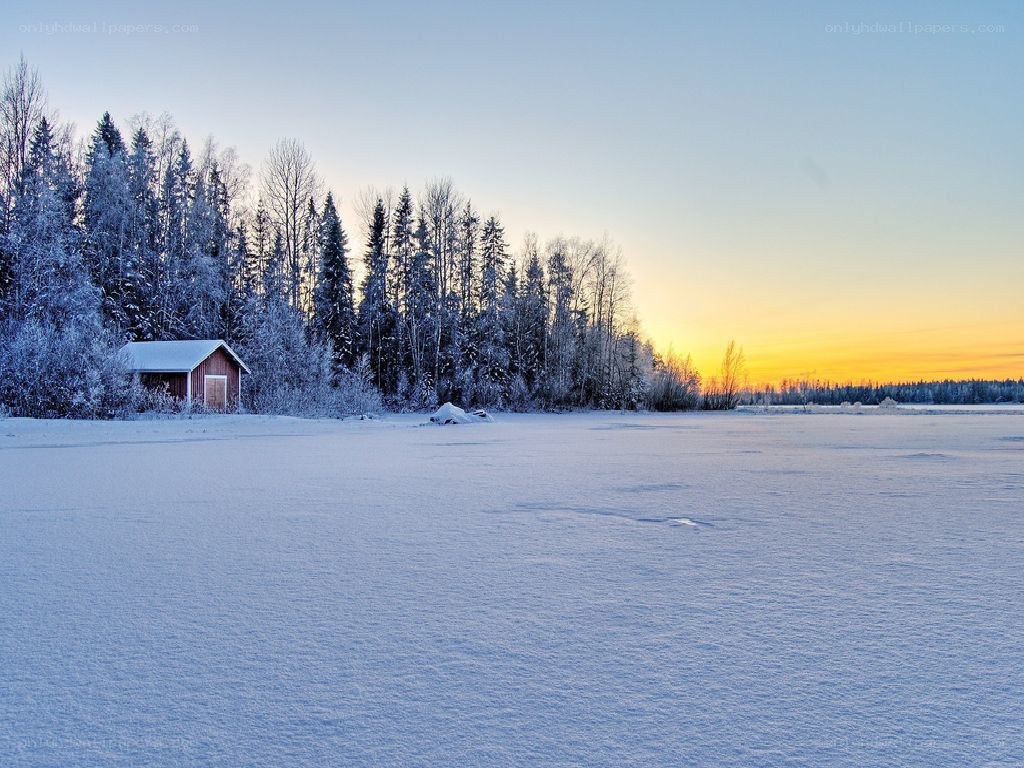Snowy cabin at sunset