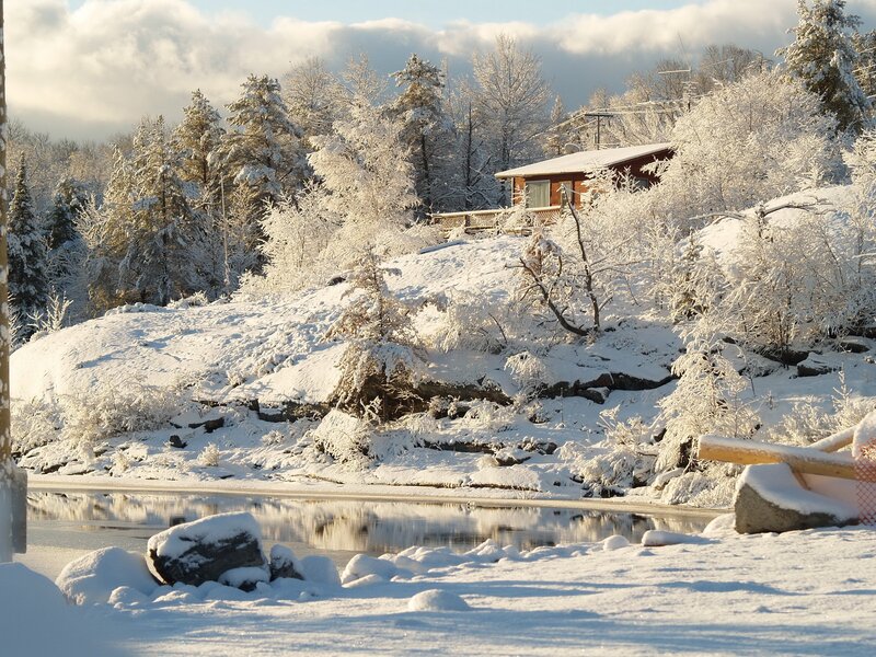 Snowy cabin by a lake