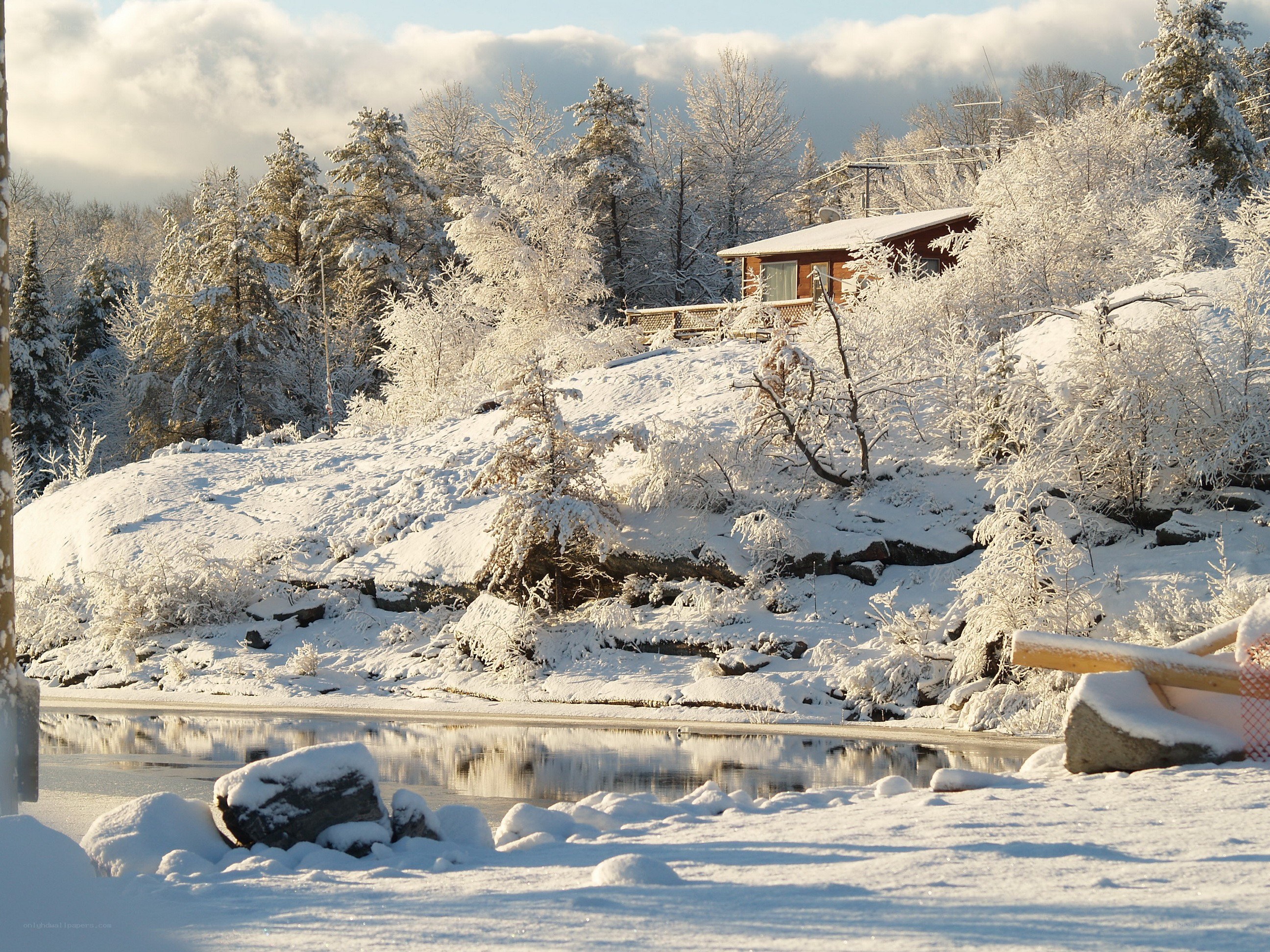 Snowy cabin by a lake