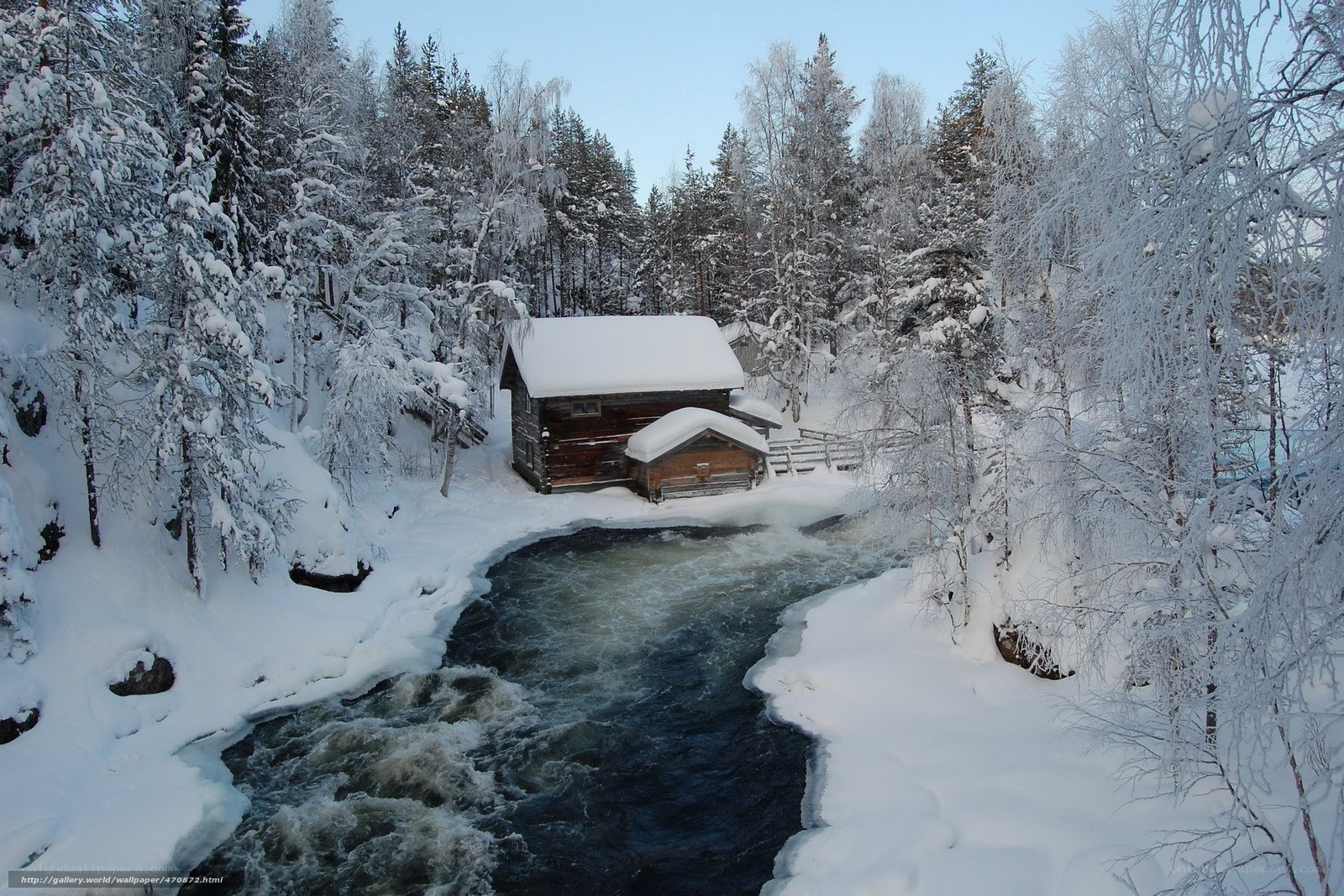 Snowy cabin by a river