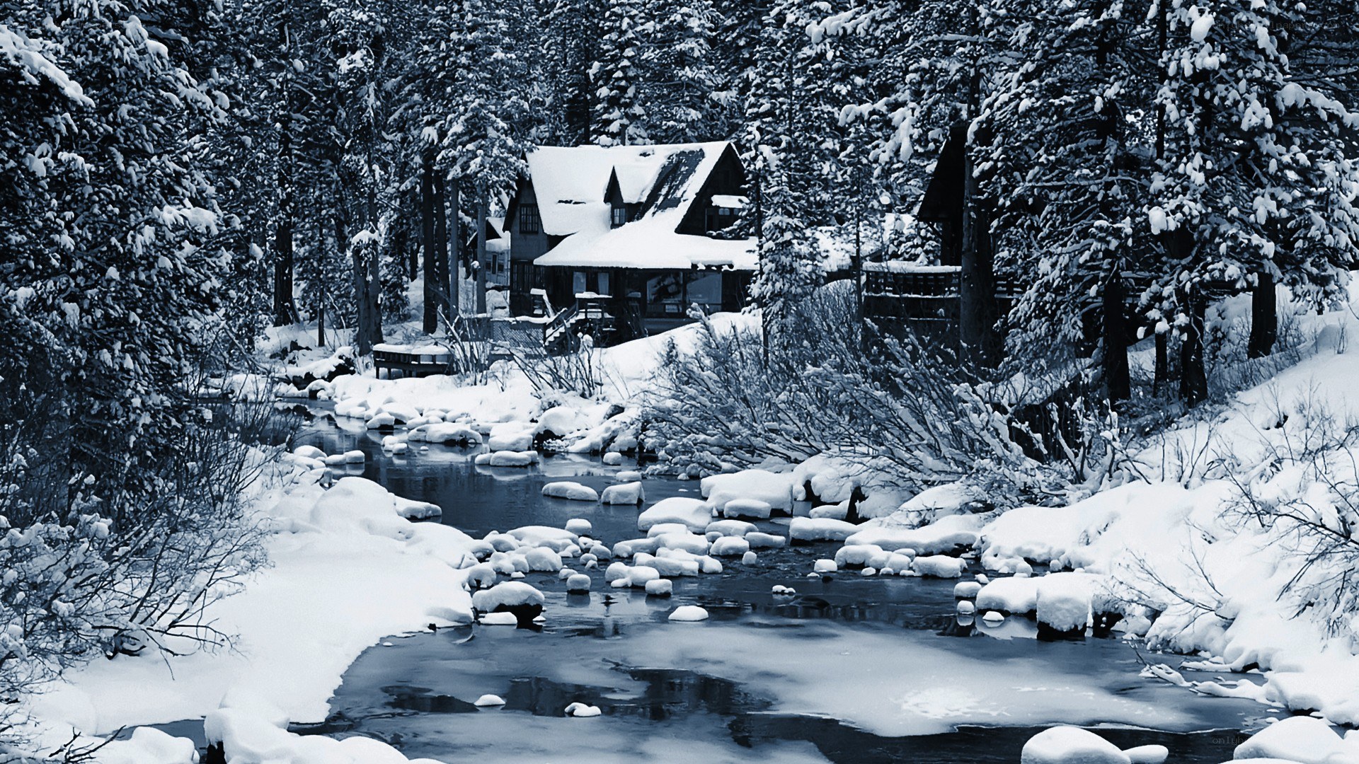 Snowy cabin by a river