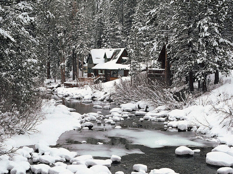 Snowy cabin by a river