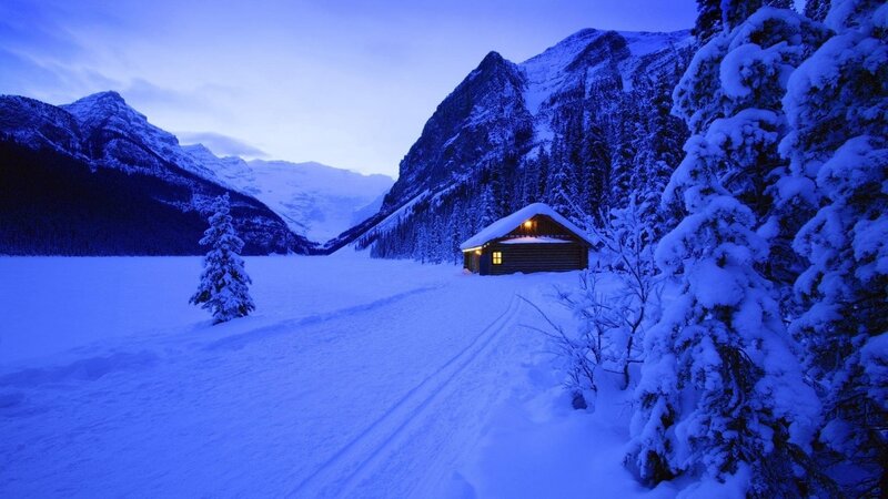 Snowy cabin in mountain valley