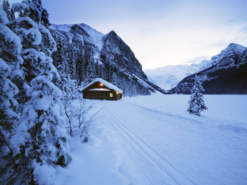 Snowy cabin in mountain valley