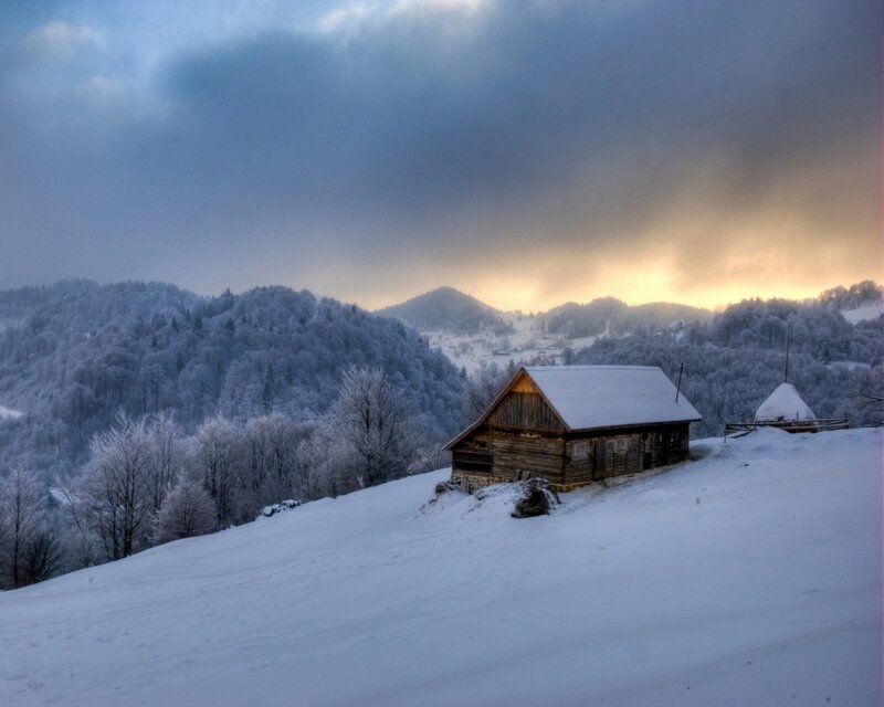 Snowy cabin in mountain valley