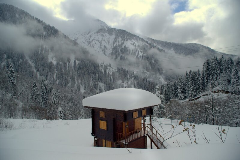 Snowy cabin in mountain valley