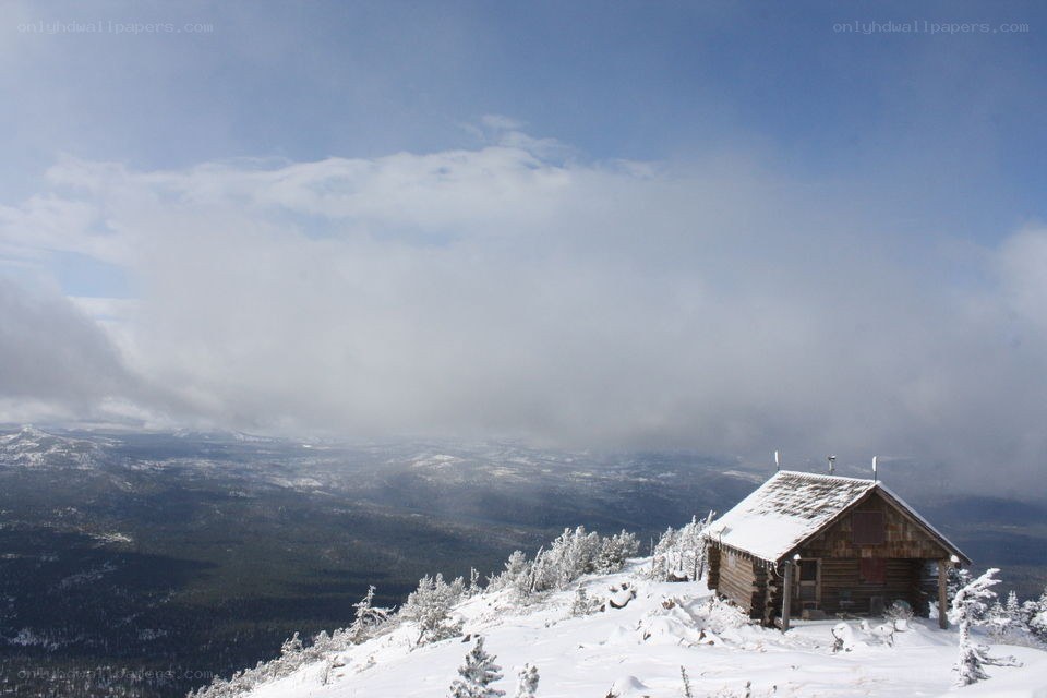 Snowy cabin on mountain peak
