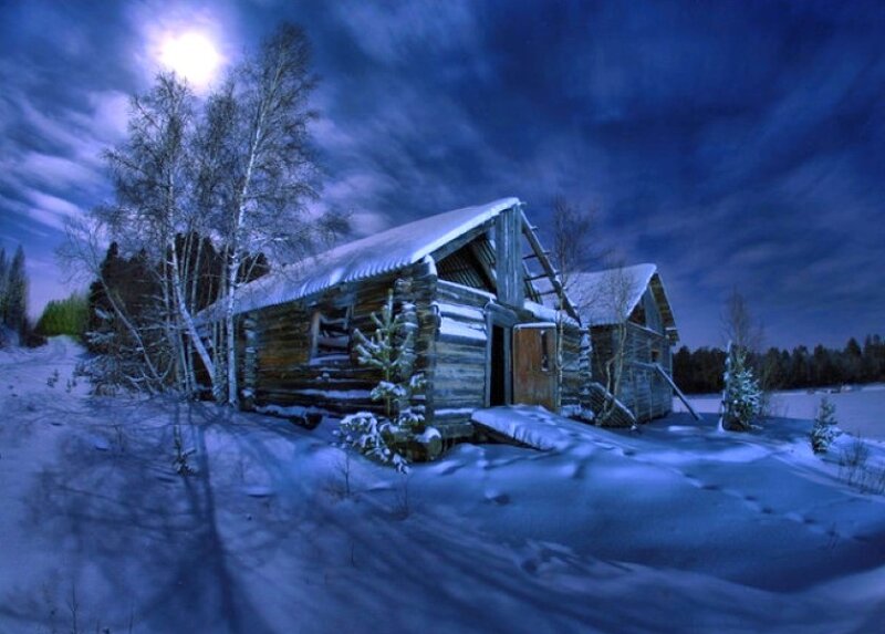 Snowy cabin under moonlight