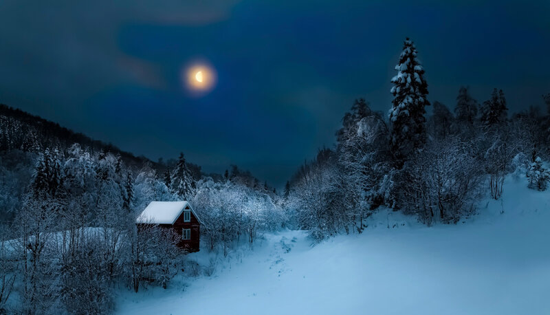 Snowy cabin under moonlight