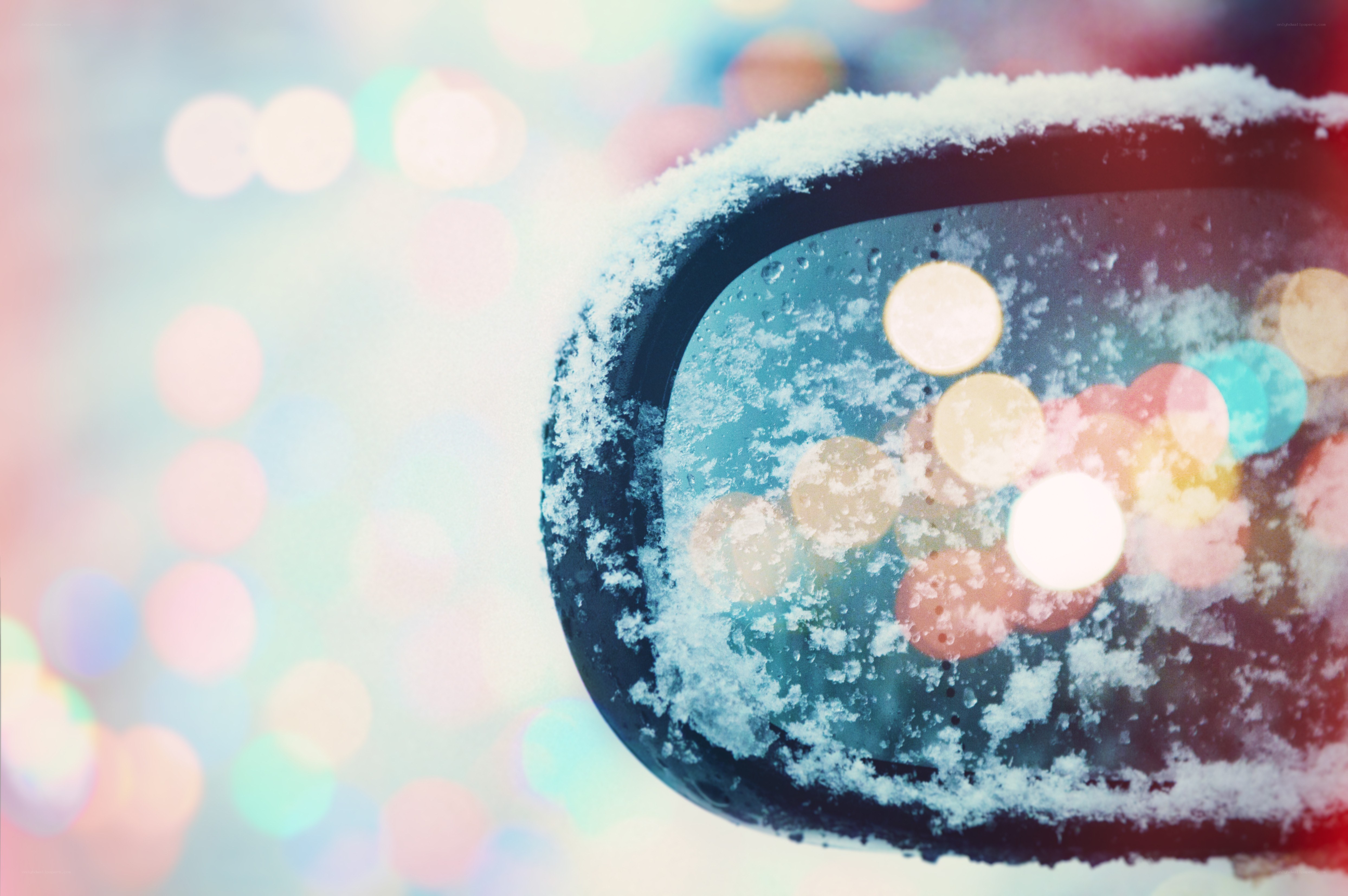 Snowy car mirror with bokeh lights