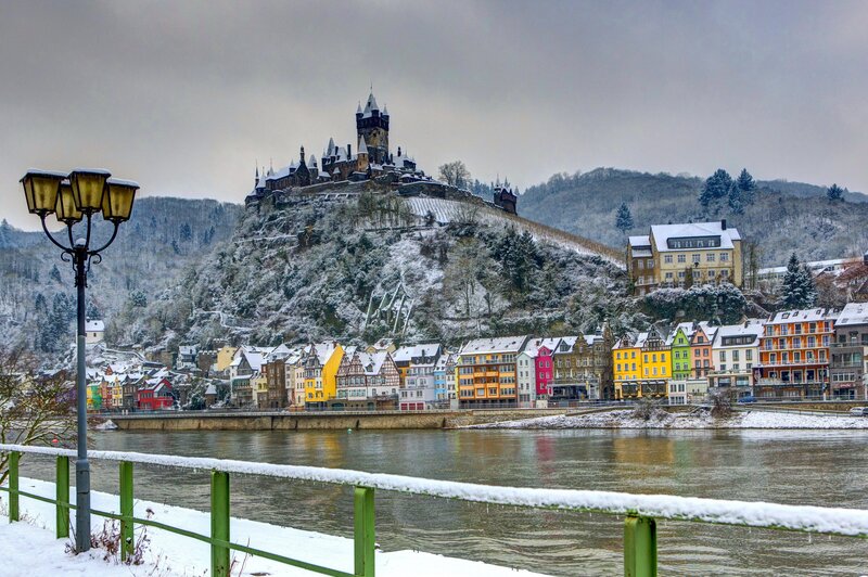 Snowy castle overlooking a river town