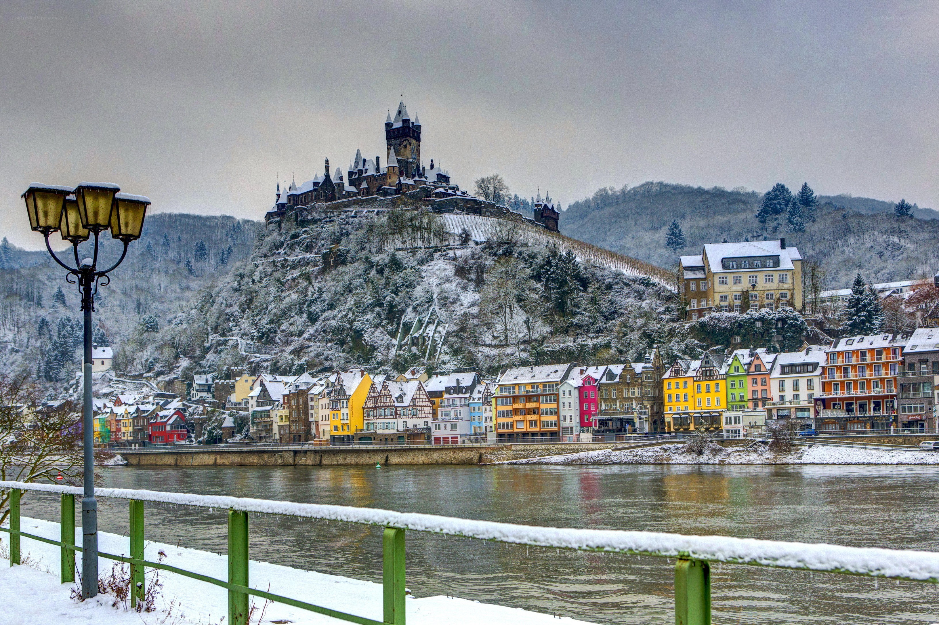 Snowy castle overlooking a river town
