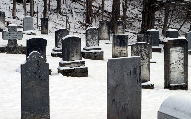 Snowy cemetery with old gravestones