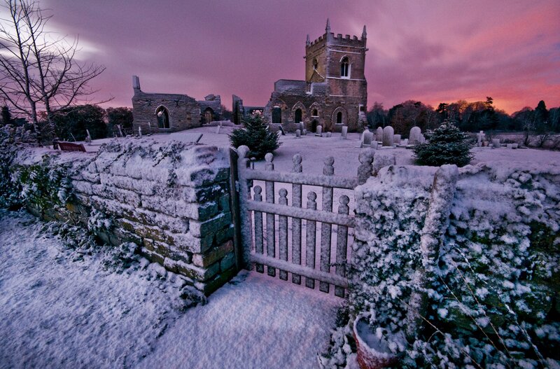 Snowy church ruins at sunset