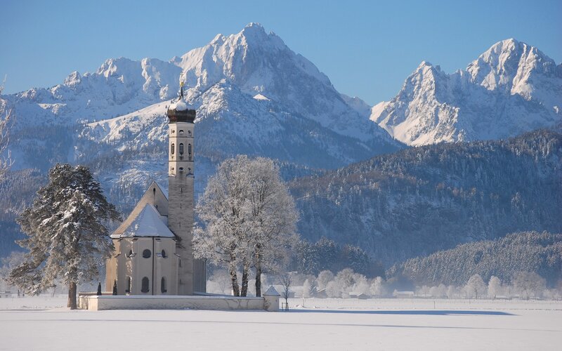 Snowy church with mountain backdrop