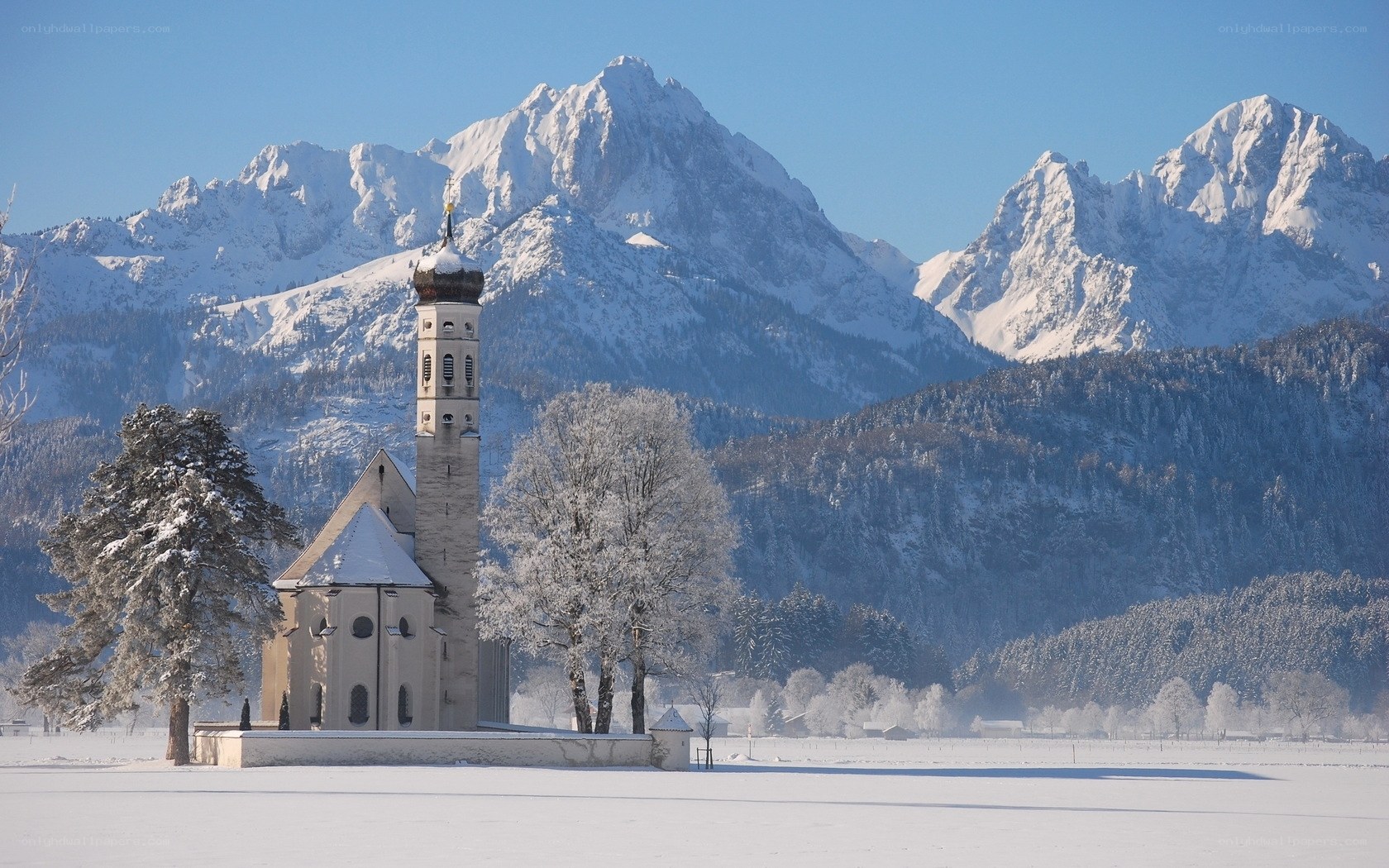 Snowy church with mountain backdrop