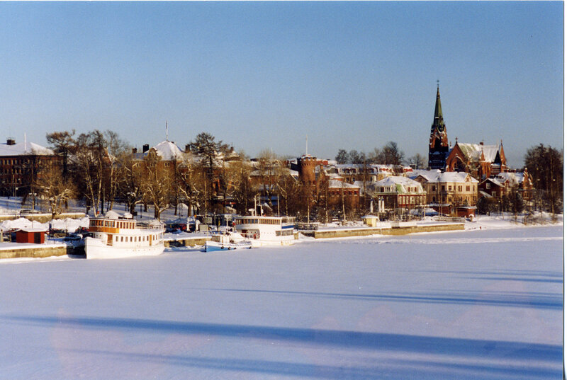 Snowy city by frozen water