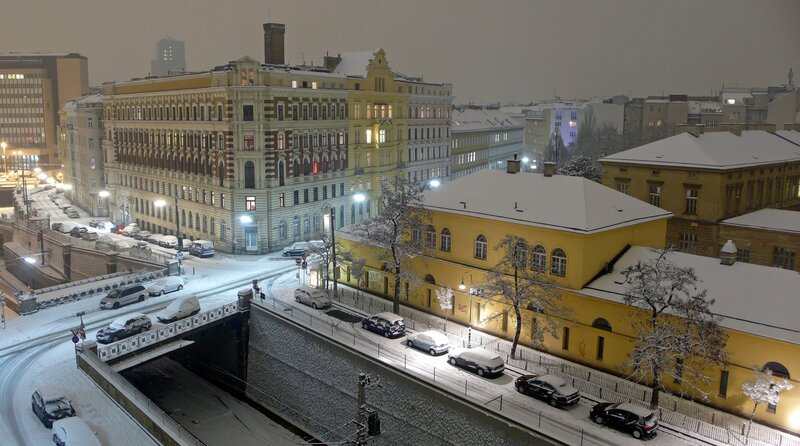 Snowy city street at night