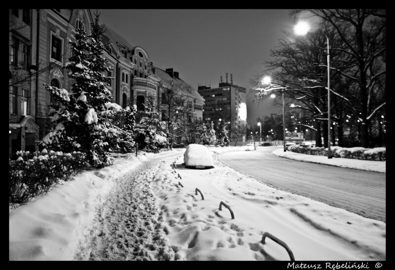 Snowy city street at night
