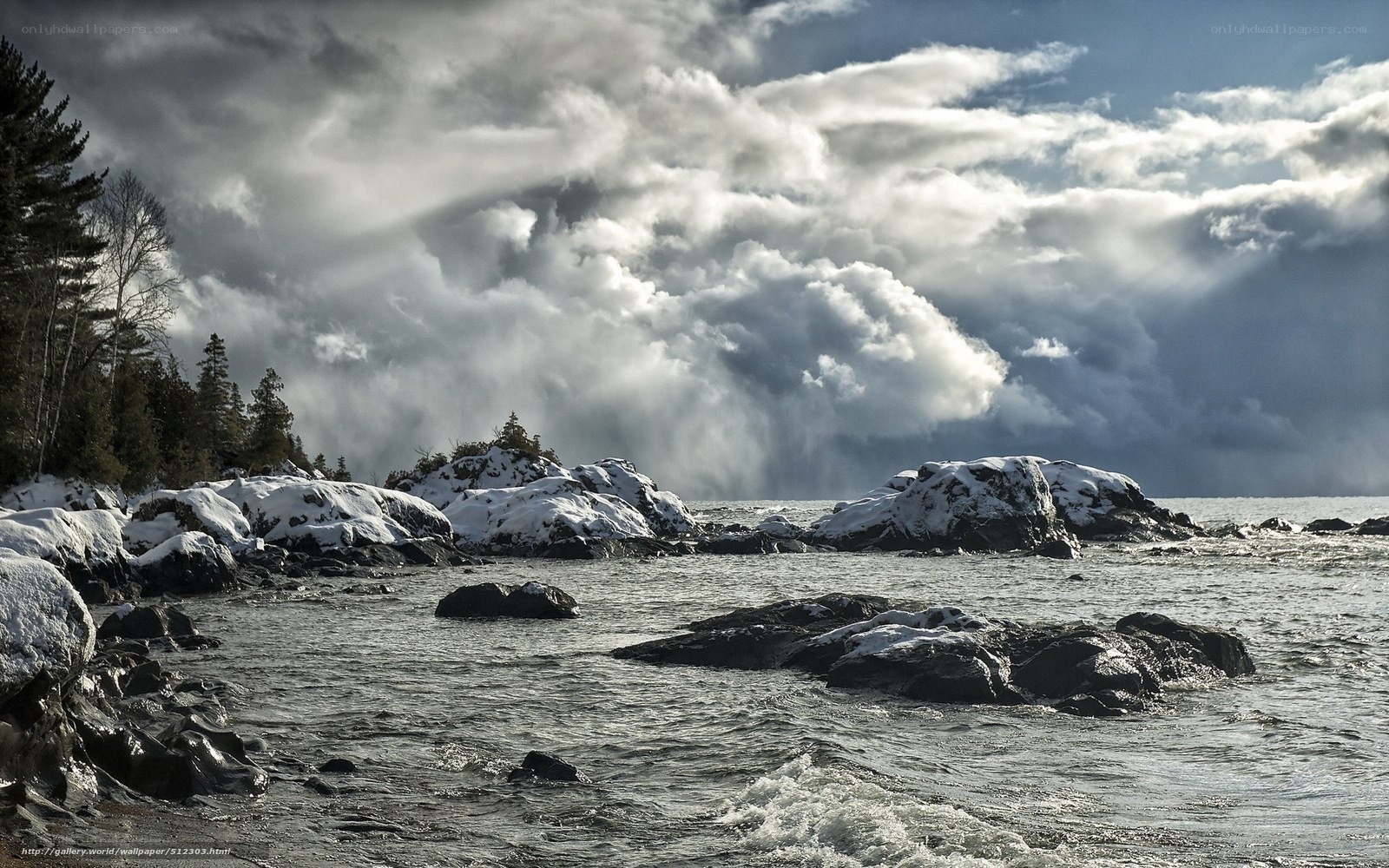 Snowy coastal rocks under storm clouds