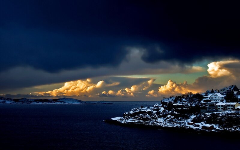Snowy coastal town at sunset