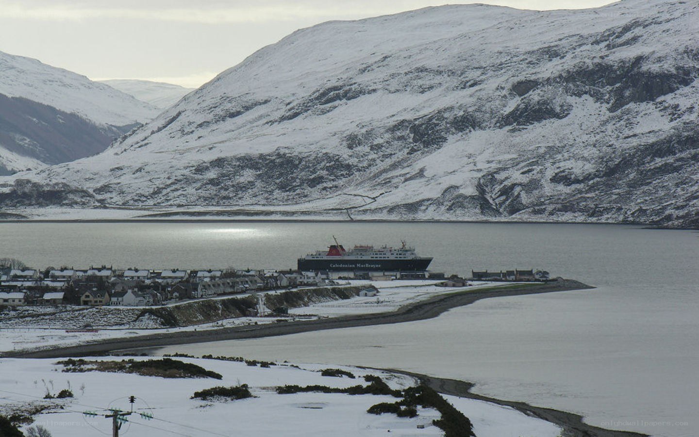 Snowy coastal town with ferry