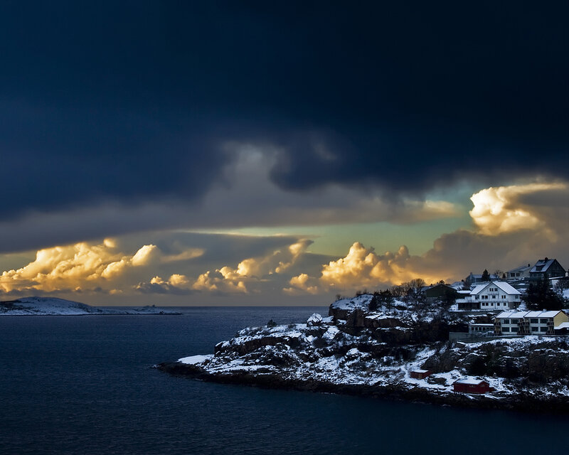 Snowy coastal village at dusk