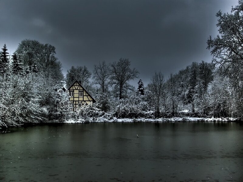 Snowy cottage by a lake