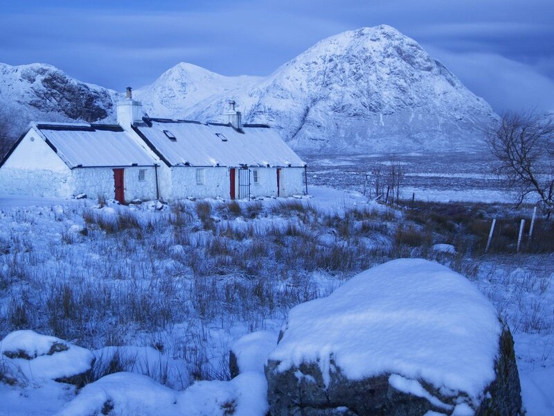 Snowy cottage in mountain valley