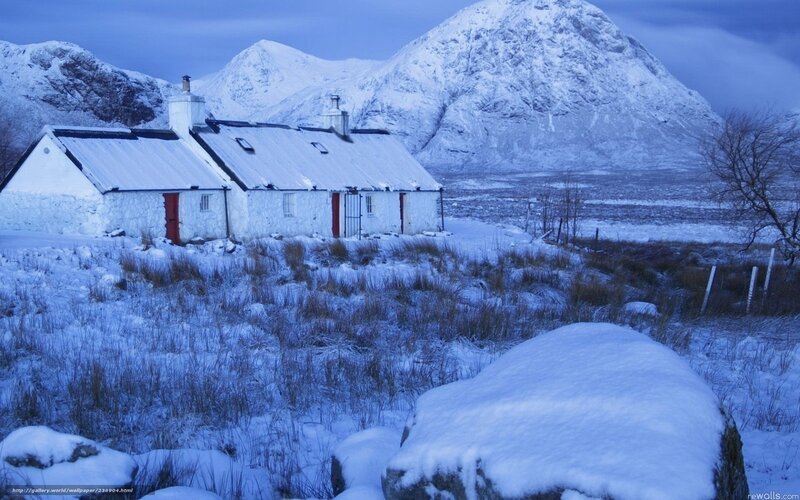 Snowy cottage in mountain valley