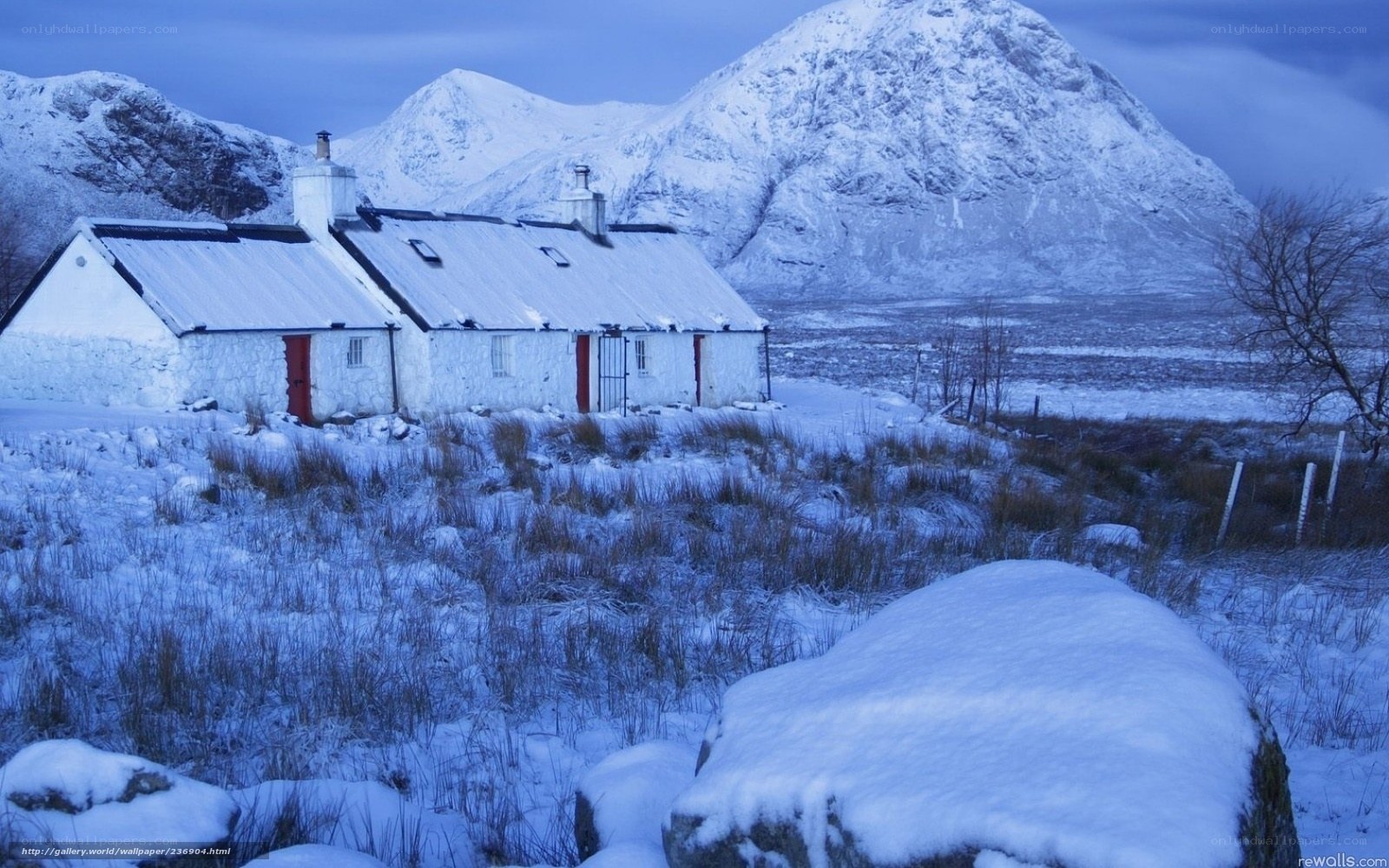 Snowy cottage in mountain valley