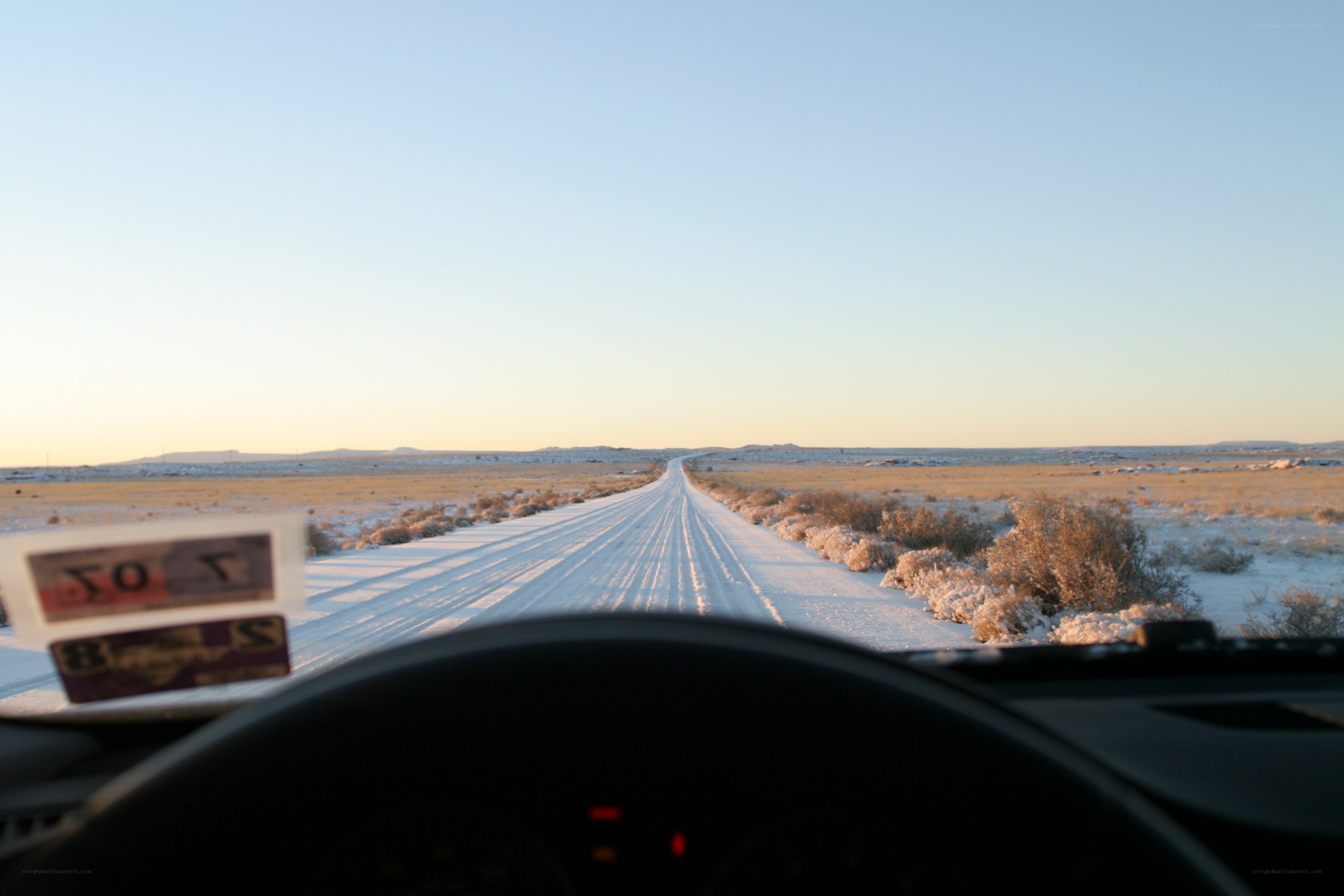 Snowy desert road at sunset