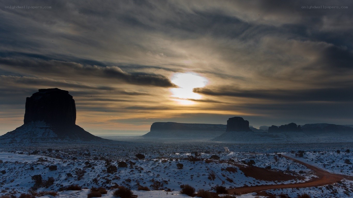 Snowy desert sunset with rock formations