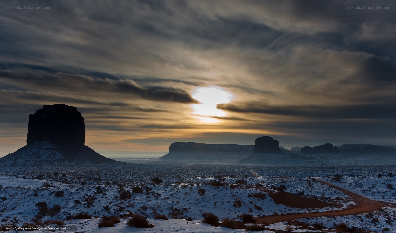 Snowy desert sunset with rock formations