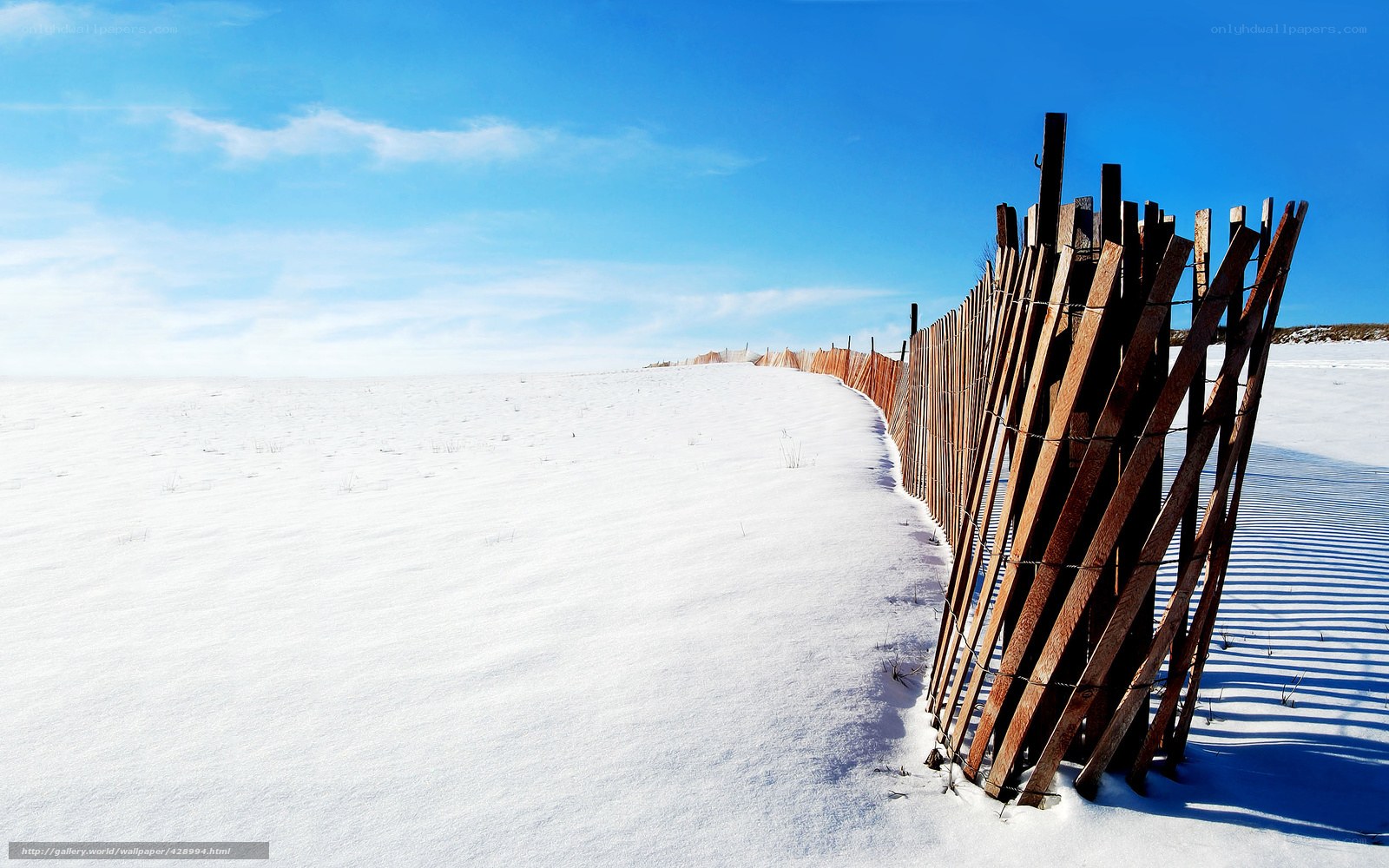 Snowy dune with wooden fence