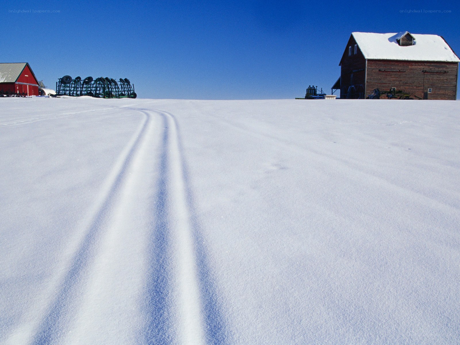 Snowy farm with tractor tracks