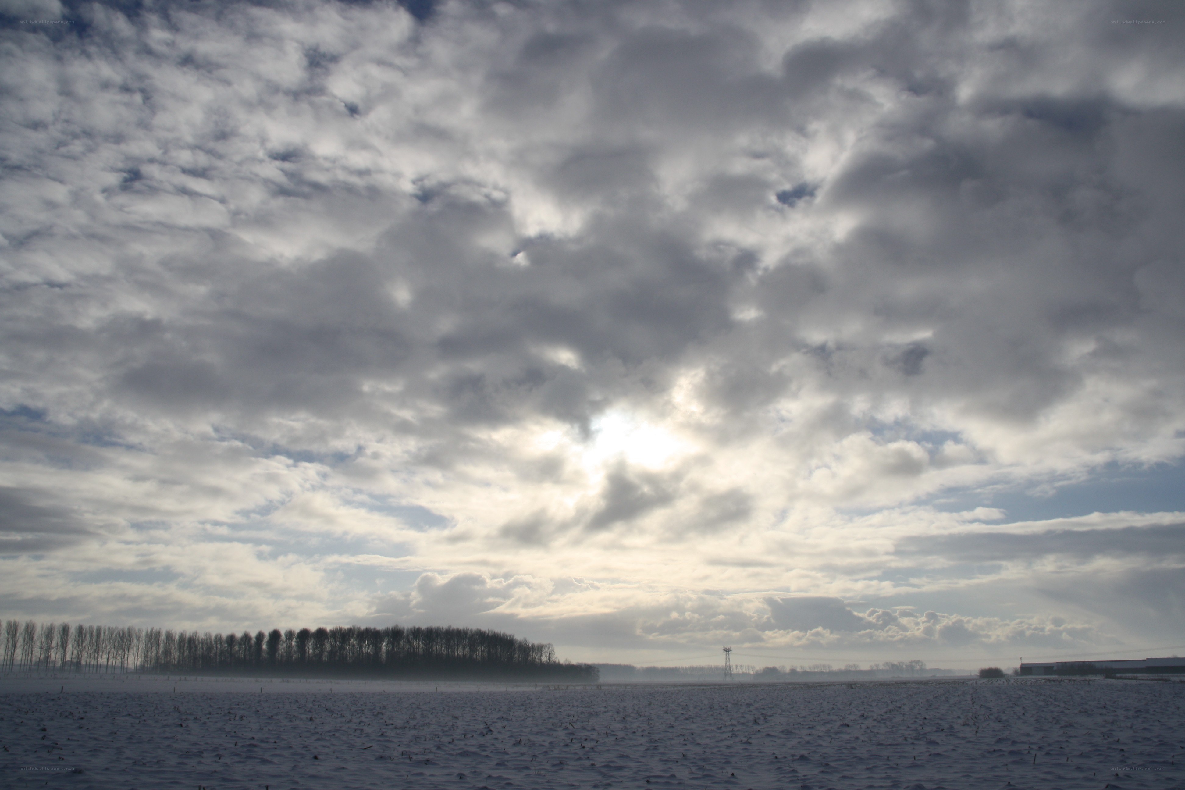 Snowy field under cloudy sky
