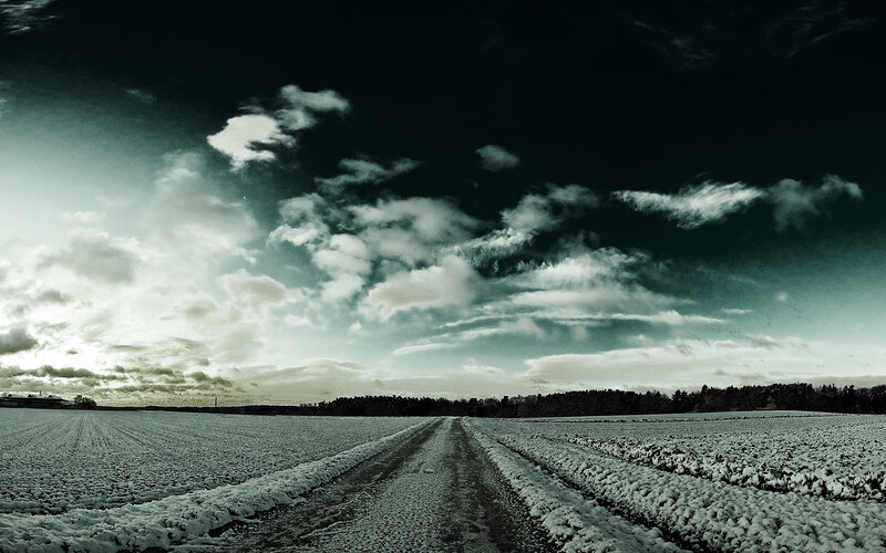 Snowy field under cloudy sky