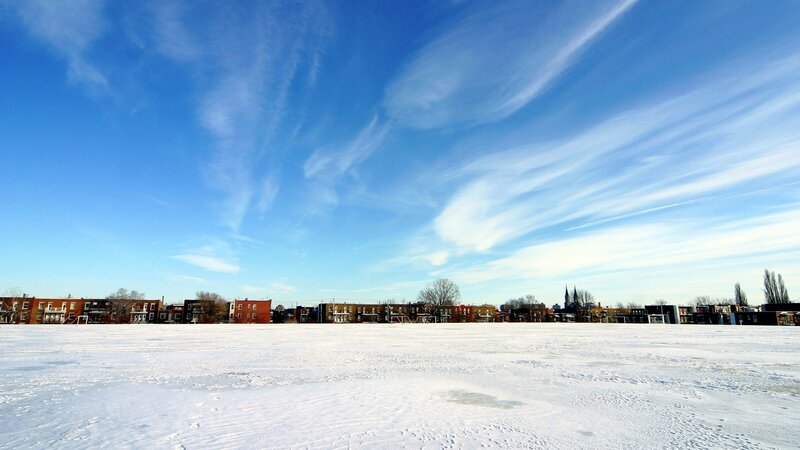Snowy field with city skyline