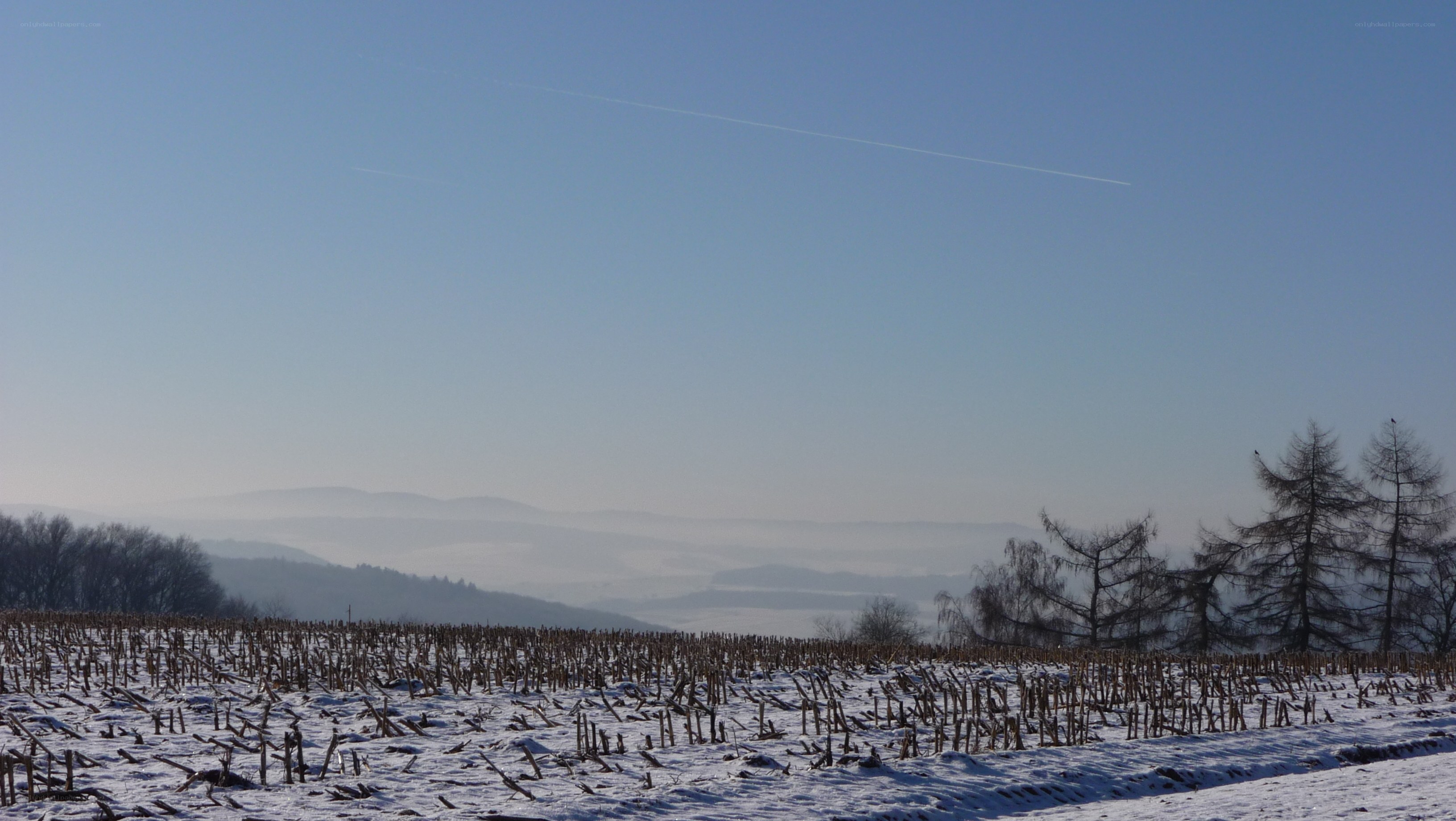 Snowy field with distant hills
