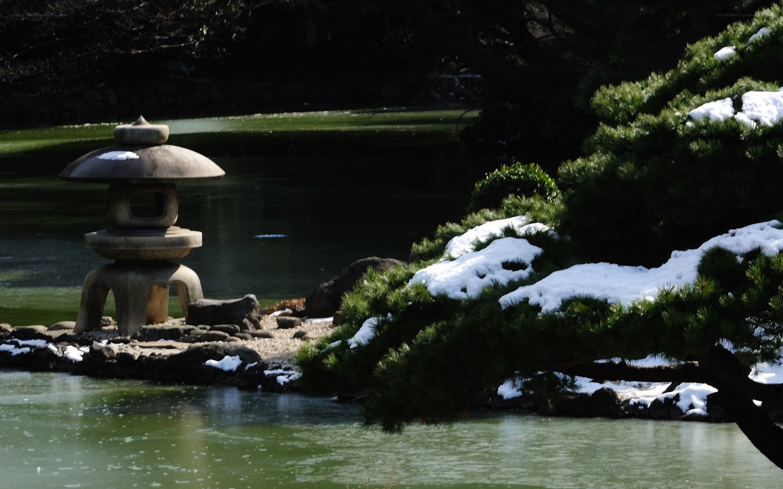 Snowy garden lantern by pond